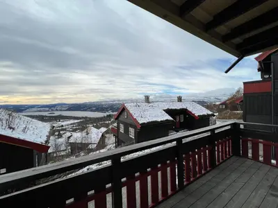 a balcony with snow on the roofs of houses at Cozy apt with a view in Beitostøl