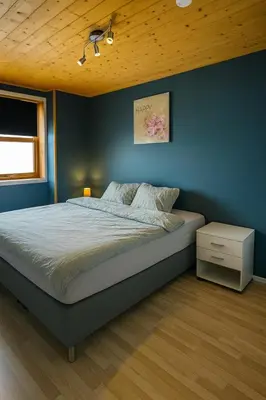 a bedroom with a bed and a blue wall at Leilighet med særpreg in Lillehammer