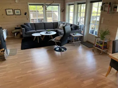 a living room with a couch and tables at Modern, lovely holidayhome, in quiet nature close to Trolltunga in Utsikten
