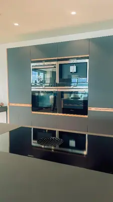 a kitchen with stainless steel cabinets with a black grate at Magical view towards the fjords by the sea in Ålesund