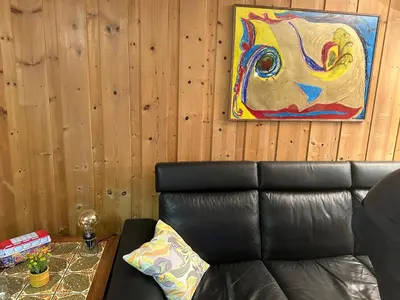 a couch in a room with a painting on the wall at Trivelig leilighet med gratis parkering på stedet in Forset