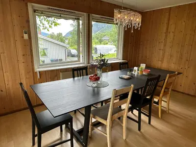 a dining room with a black table and chairs at Trivelig leilighet med gratis parkering på stedet in Forset