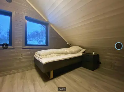 a small bed in a room with two windows at Fjellhytte med ski inn-ut in Torvetjørn
