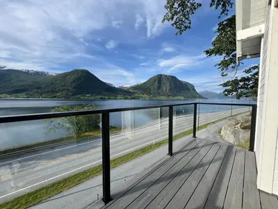 a balcony with a view of the water and mountains at Husslåttene apartments in Skei