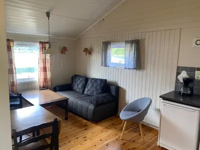 a living room with a couch and a table at Veganeset Camping in Balestrand