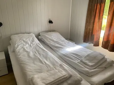 a hospital bed with white sheets in a room at Veganeset Camping in Balestrand