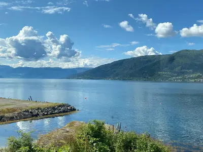 a view of a large body of water with mountains at Veganeset Camping in Balestrand