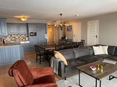 a living room with a couch and a table and a kitchen at Fjellparken 351 in Beitostøl