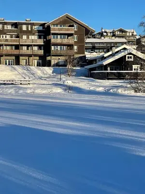 a snow covered field in front of a building at Fjellparken 351 in Beitostøl