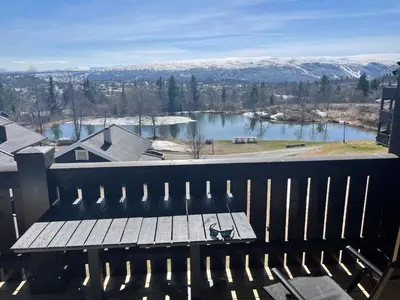 a picnic table on a balcony with a view of a lake at Fjellparken 351 in Beitostøl