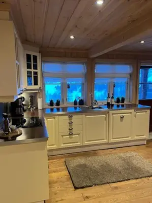 a large kitchen with white cabinets and windows at Hytte Gaustablikk in Gaustablikk