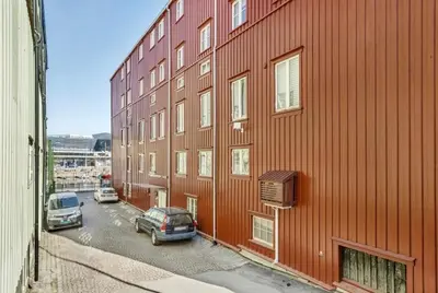 a red building with cars parked in front of it at Sentral 2-romsleilighet in Trondheim
