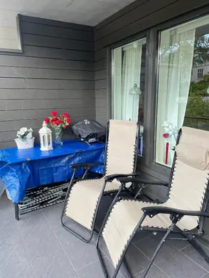 two chairs and a table on a porch at Flott leilighet in Bergen