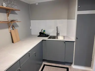 a kitchen with gray cabinets and a sink at Koselig leilighet i Ålesund sentrum in Ålesund