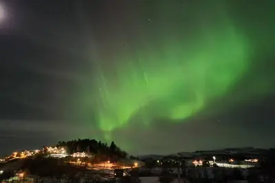 an aurora in the sky over a city at night at Shelby's Home in Heimstad