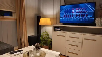 a living room with a tv and a table with a table sidx sidx at Shelby's Home in Heimstad