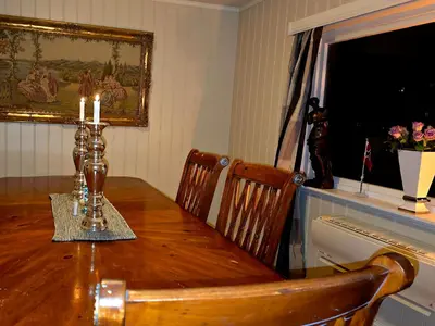 a dining room table with two chairs and candles on it at Knobelauch Family Home, Valdres in Vøle