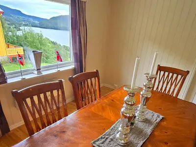 a wooden table with two candles on it with a window at Knobelauch Family Home, Valdres in Vøle