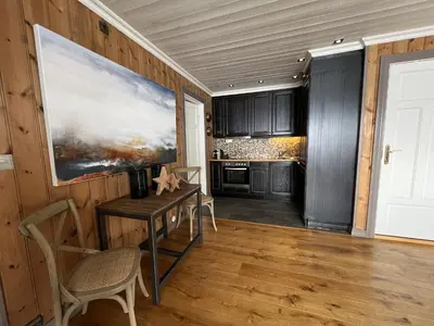 a kitchen with a table and a painting on the wall at Cozy Apartment With Stunning Mountain Views in Beitostøl