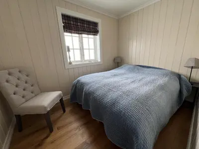 a bedroom with a bed and a chair and a window at Cozy Apartment With Stunning Mountain Views in Beitostøl