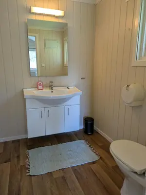 a bathroom with a sink and a toilet and a mirror at Oldevatn Camping in Olden