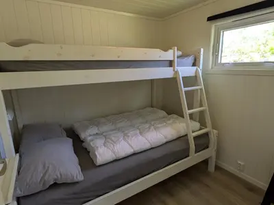 a bedroom with two bunk beds and a window at Oldevatn Camping in Olden