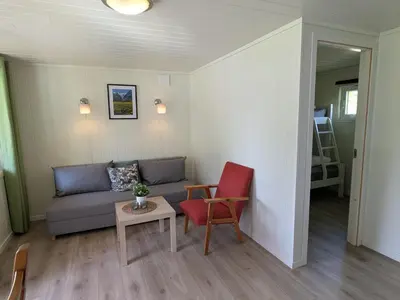 a living room with a couch and a table and chairs at Oldevatn Camping in Olden