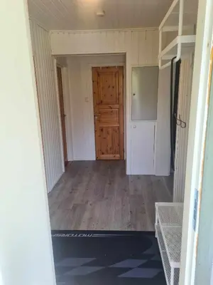 an empty room with a kitchen and a door at Koselig Sentrumsleilighet i 2 etg in Nes i Ådal
