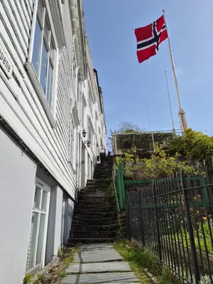 a stairway leading up to a building with a flag at Nydelig hus med privat hage og fantastisk utsikt over Fisketorget, Bryggen og Bergen sentrum in Bergen