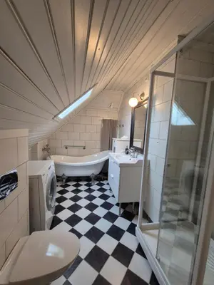 a bathroom with a tub and a sink and a toilet at Nydelig hus med privat hage og fantastisk utsikt over Fisketorget, Bryggen og Bergen sentrum in Bergen