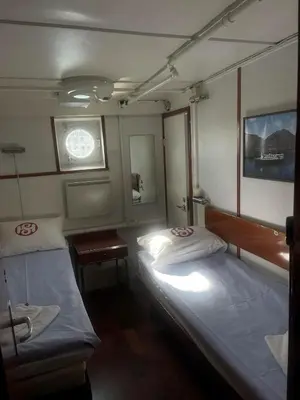 a small room with two beds and a table at Sunnhordland in Odda