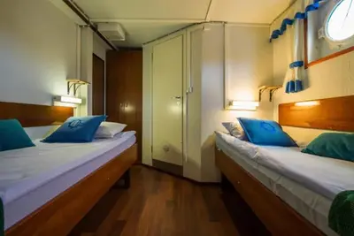 a bedroom with two beds with blue pillows on them at Sunnhordland in Odda