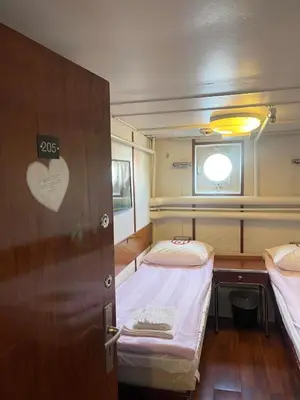 a small room with two beds and a window at Sunnhordland in Odda
