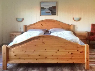 a wooden bed with two pillows in a bedroom at 11 person holiday home in Bud-By Traum in Bud