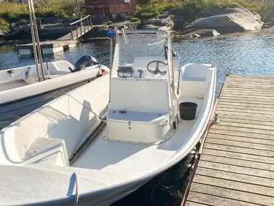 a white boat parked next to a wooden dock at 11 person holiday home in Bud-By Traum in Bud