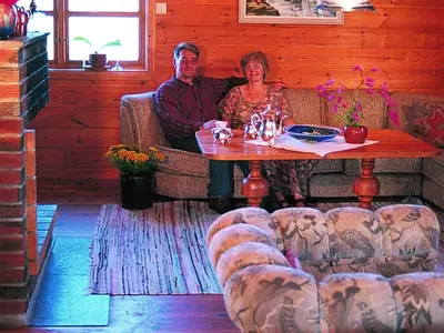 a man and woman sitting at a table in a room at 15 person holiday home in Flatanger-By Traum in Straum