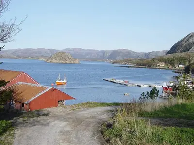 a large body of water with a red building and a dock at 15 person holiday home in Flatanger-By Traum in Straum