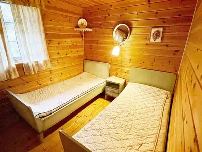 a bedroom with two beds in a wooden cabin at 6 person holiday home in Åkra-By Traum in Kyrping