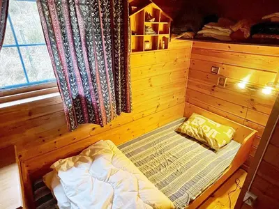 a small bed in a wooden room with a window at 6 person holiday home in Åkra-By Traum in Kyrping