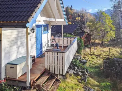 a woman sitting on a porch of a house at 6 person holiday home in Åkra-By Traum in Kyrping