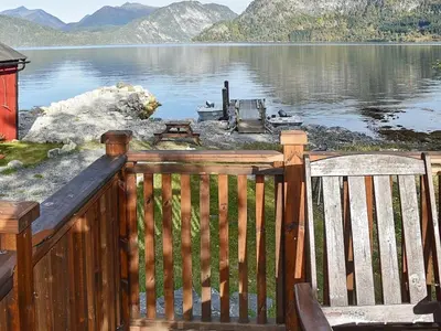 a wooden deck with two chairs and a view of a lake at 4 person holiday home in Måndalen-By Traum in Sæbø