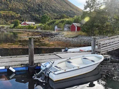 a white boat is docked next to a dock at 4 person holiday home in Måndalen-By Traum in Sæbø