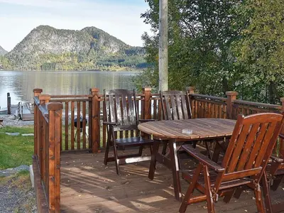 a wooden deck with a wooden table and chairs at 4 person holiday home in Måndalen-By Traum in Sæbø