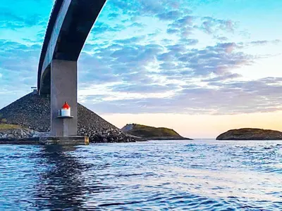 a bridge over a body of water with a lighthouse at 10 person holiday home in VEVANG-By Traum in Vevang