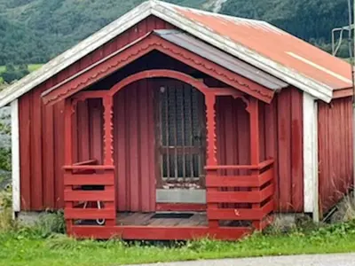 a red barn with an open door in a field at 4 person holiday home in Eresfjord-By Traum in Øverås