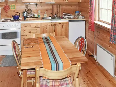 a kitchen with a wooden table with chairs and a stove at 5 person holiday home in Brekke-By Traum in Dingja