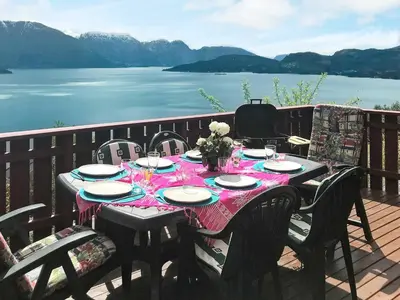 a table on a deck with a view of the water at 8 person holiday home in Norheimsund-By Traum in Norheimsund