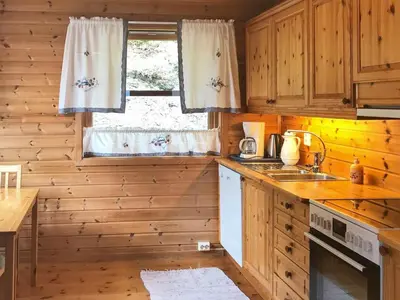 a kitchen with wooden cabinets and a sink and a window at 8 person holiday home in Norheimsund-By Traum in Norheimsund
