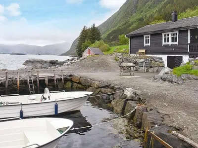 a boat is docked in front of a house at 7 person holiday home in Selje-By Traum in Selje