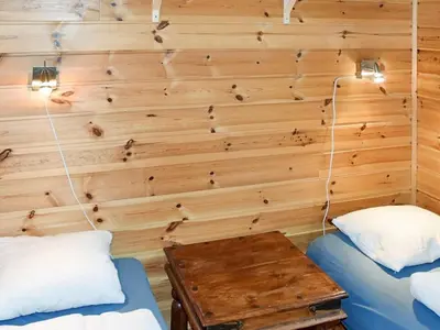 a room with two beds and a wooden wall at 7 person holiday home in Selje-By Traum in Selje